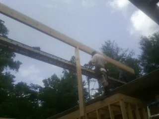 Carpenter setting a ridge beam over a new addition frame — Ice Dam Removal by Roofing Brothers in Illinois City