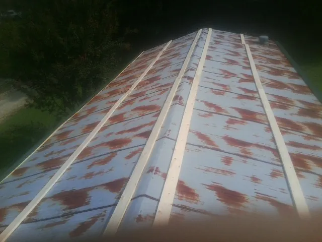 Rusted metal roof panels with new wood purlins before replacement — Storm Damage Roof Repair in Illinois City by Roofing Brothers