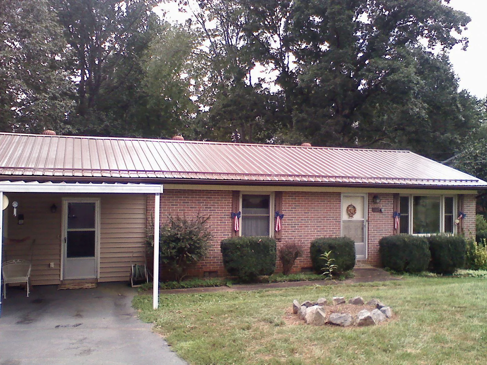 Bronze metal roof and carport on a brick ranch home — Roof Repair work by our crew in Illinois City