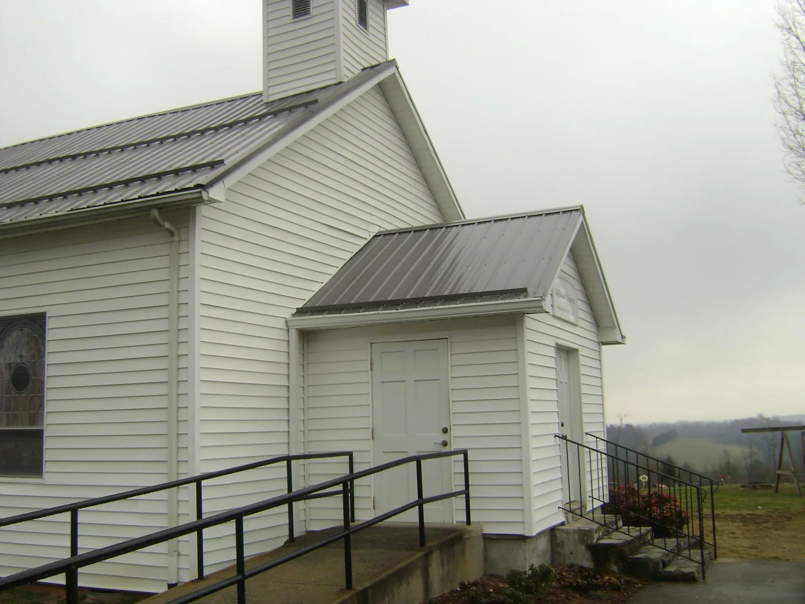 Gray metal roof on a white clapboard church with a steeple in Illinois City